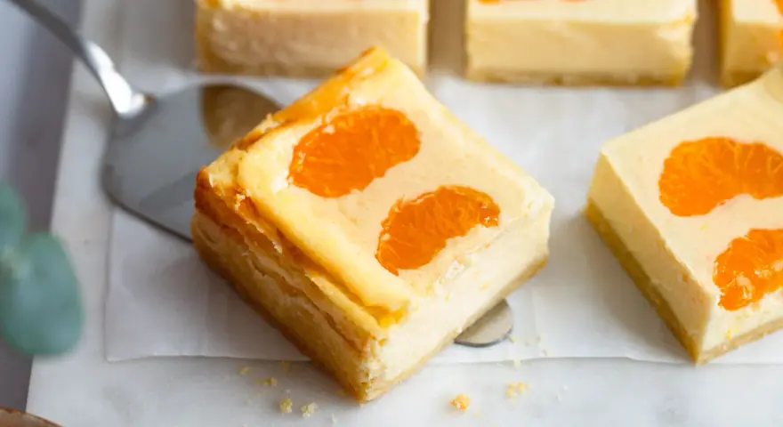 Saftige Stücke von faule weiber kuchen mit Mandarinen auf einem Marmorsockel.