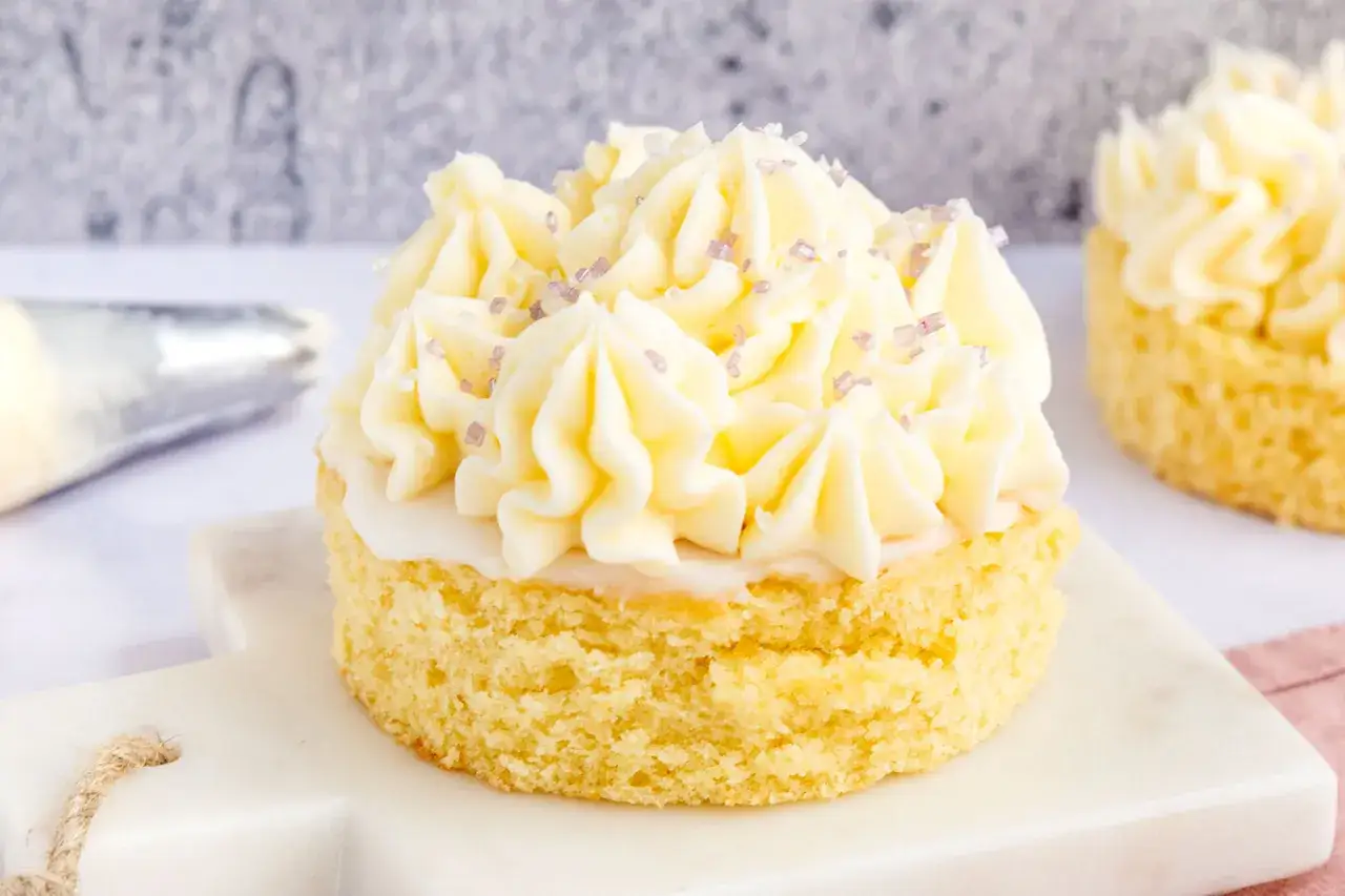 Ein kleiner Kuchen mit Omas Buttercreme ohne Pudding, verziert mit zarten lila Streuseln.