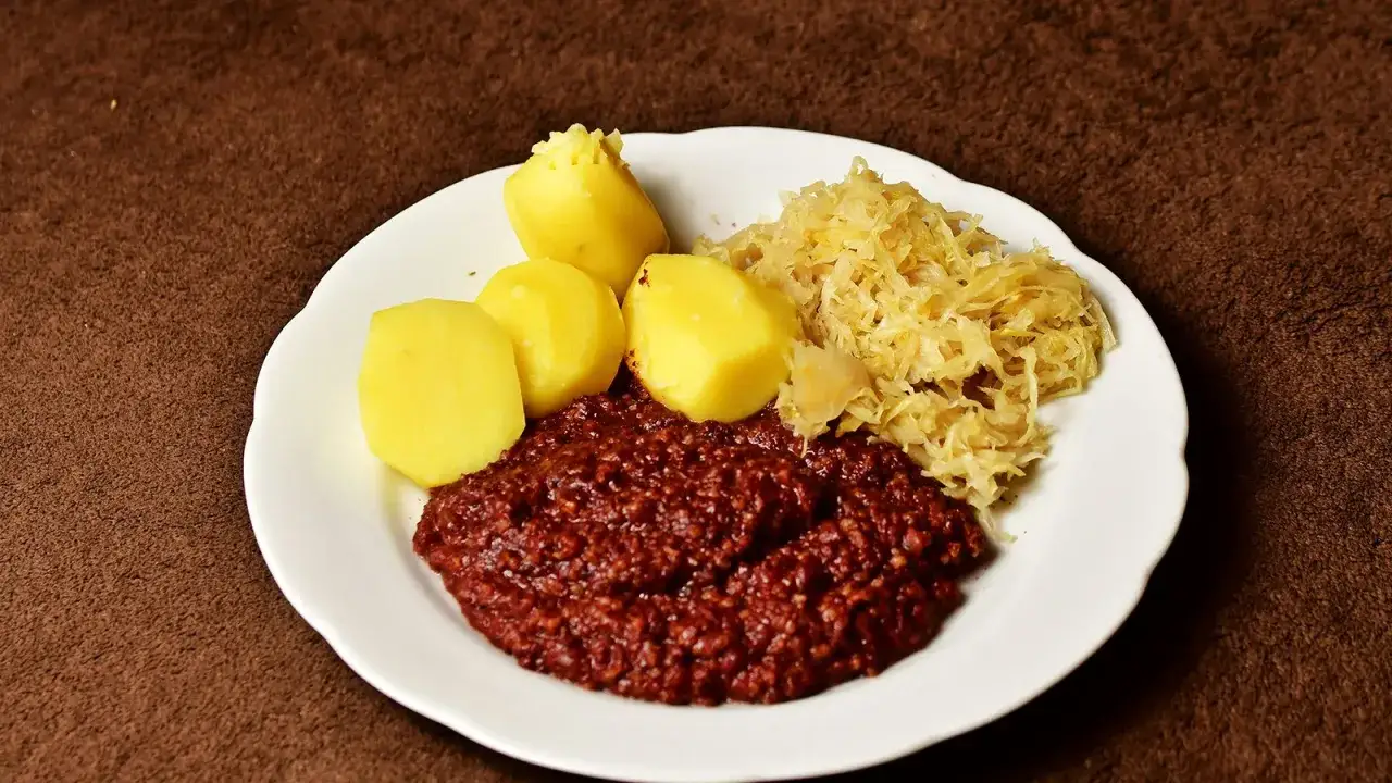 Herzhaftes Gericht mit Kartoffeln, Sauerkraut und einer deftigen Hackfleischsoße, wie es die tote Oma früher zubereitete.