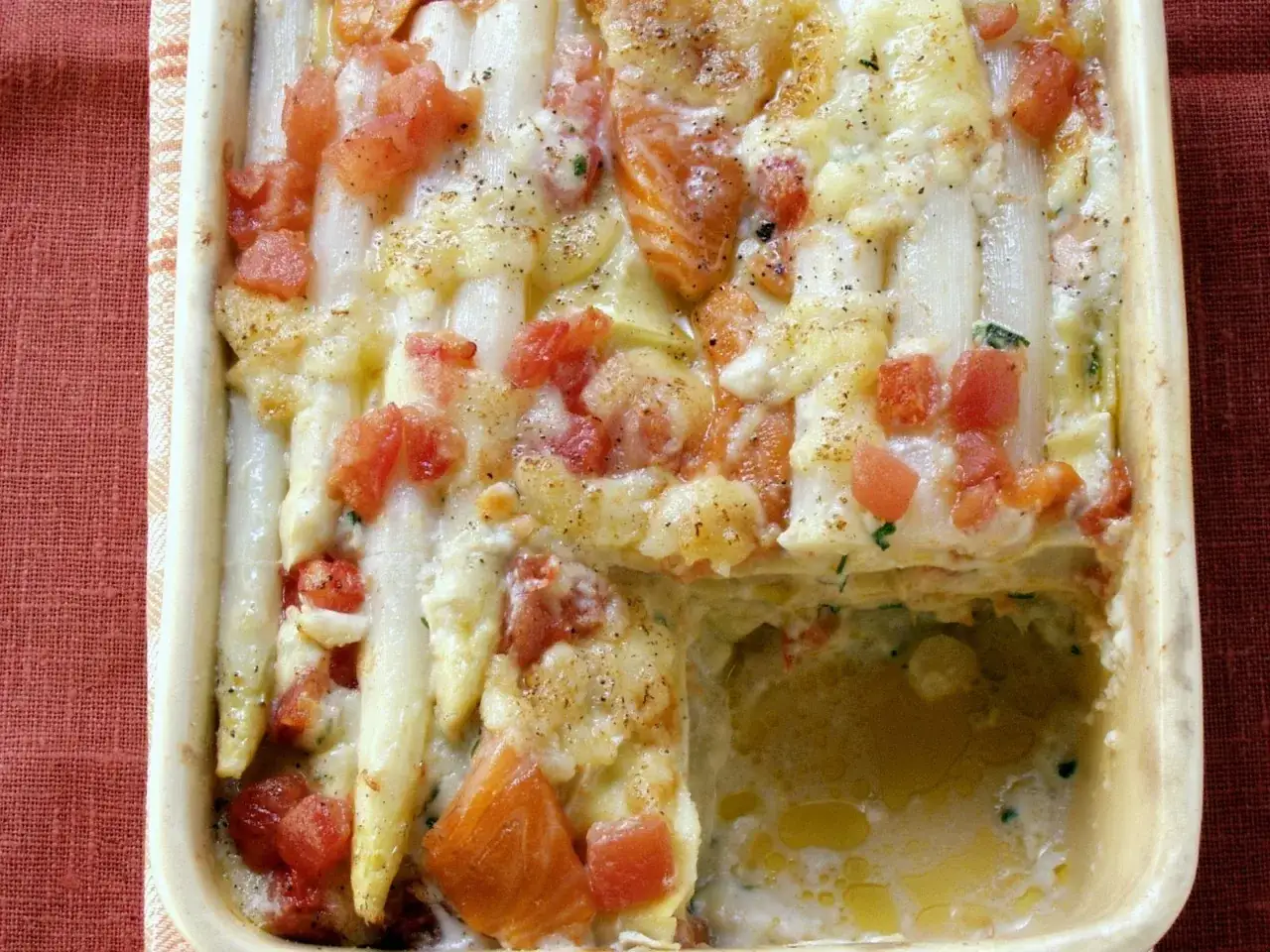 Ein köstlicher Spargelauflauf mit Lachs, überbacken mit Käse und Tomatenstücken.