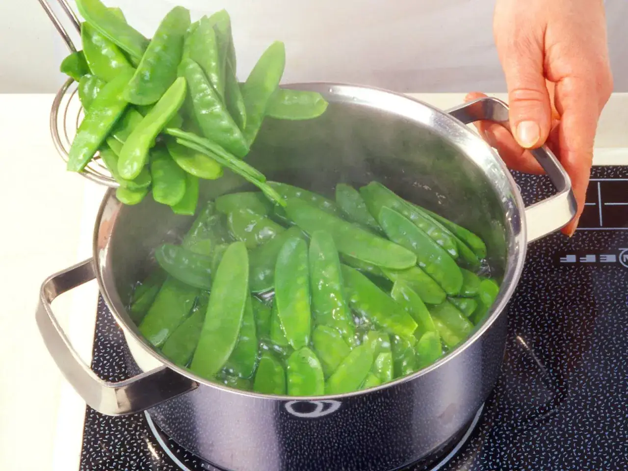 Zuckerschoten werden in einem Topf mit kochendem Wasser zubereitet. Ein einfaches zuckerschoten rezept für eine gesunde Beilage.