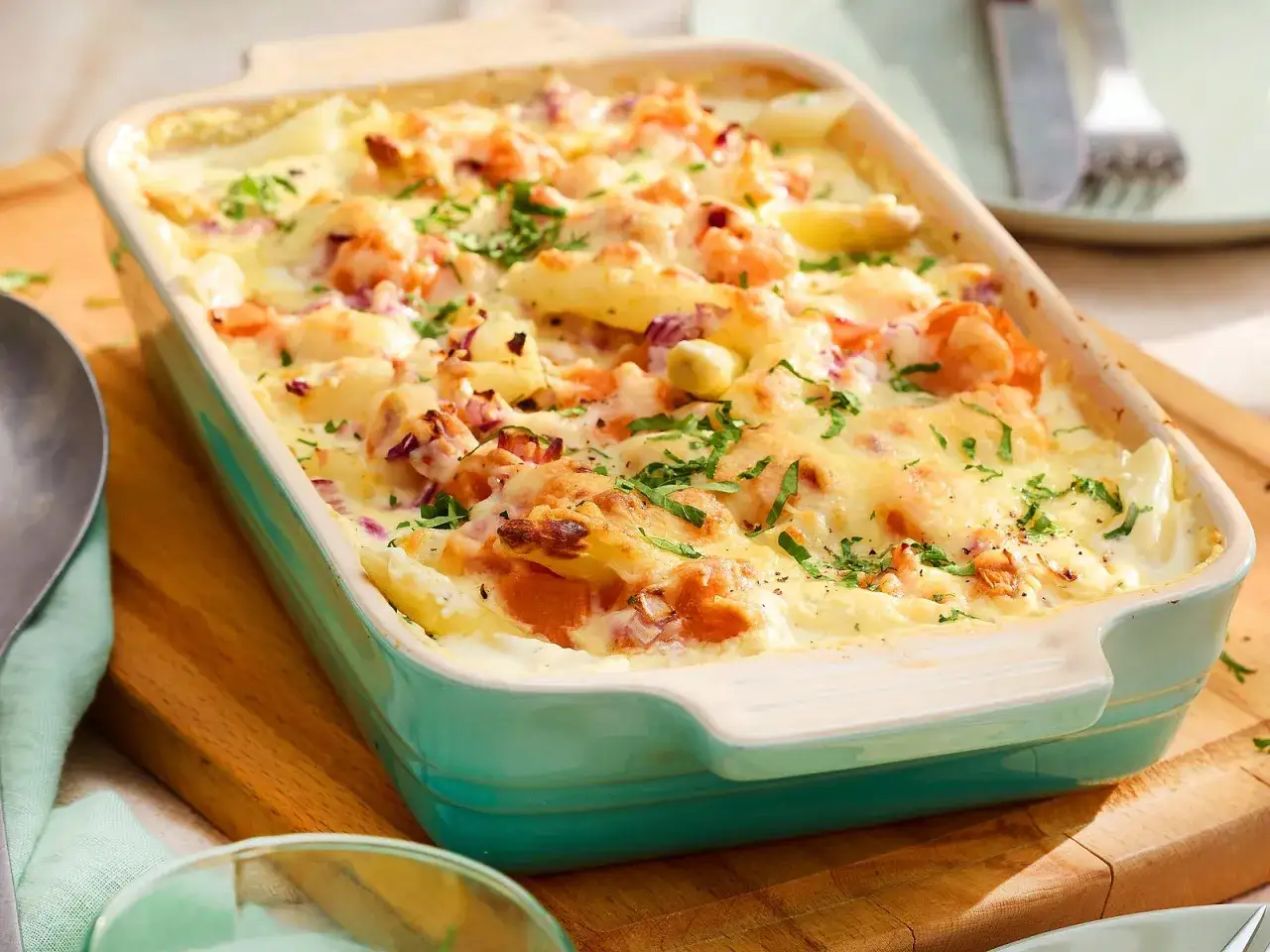 Ein köstlicher Spargel Auflauf mit Lachs und cremiger Sauce, überbacken mit goldbraunem Käse und garniert mit frischer Petersilie.
