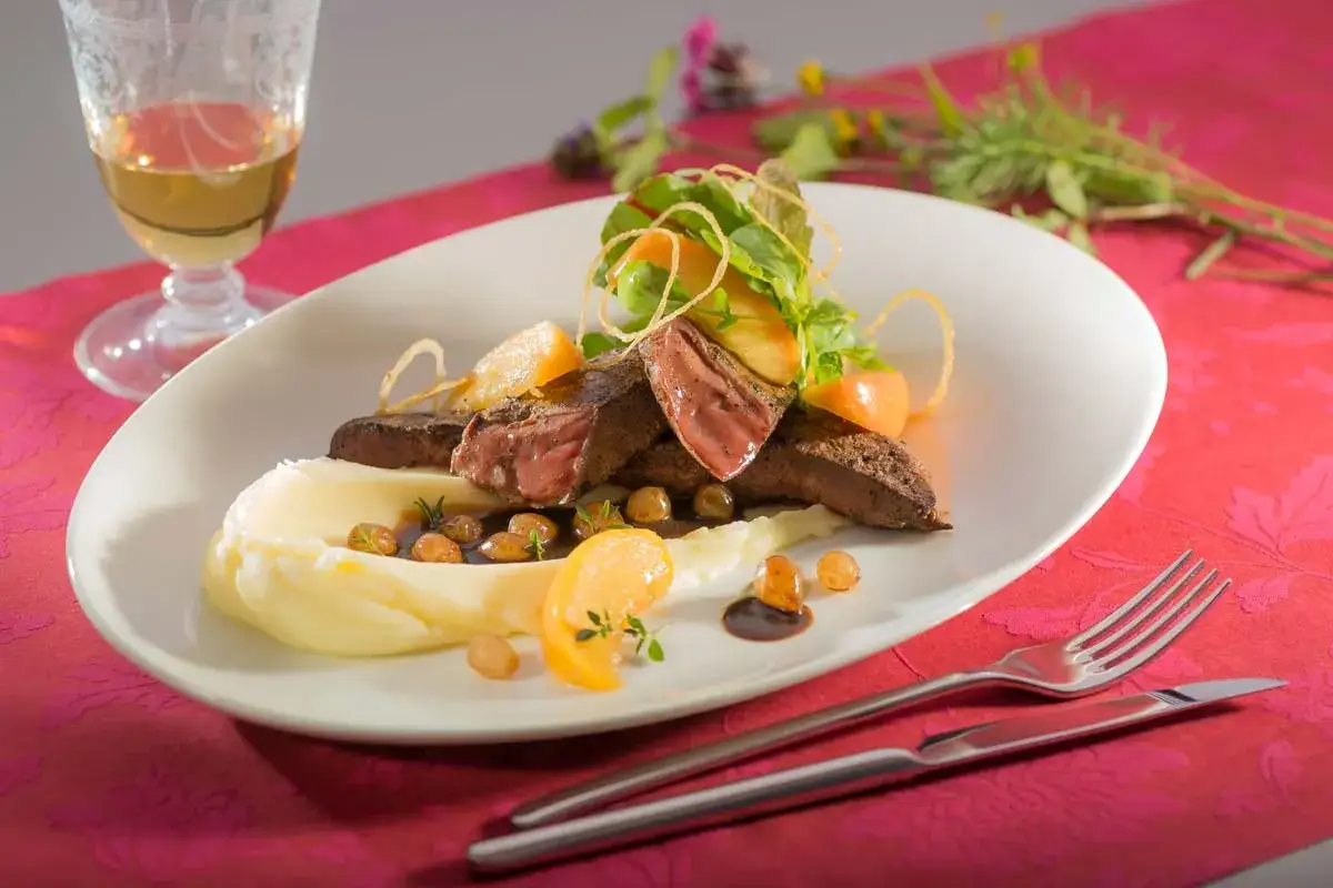 Ein köstliches Kalbsleber Rezept: Gebratene Kalbsleber mit cremigem Kartoffelpüree, Apfelspalten und einer dunklen Sauce.