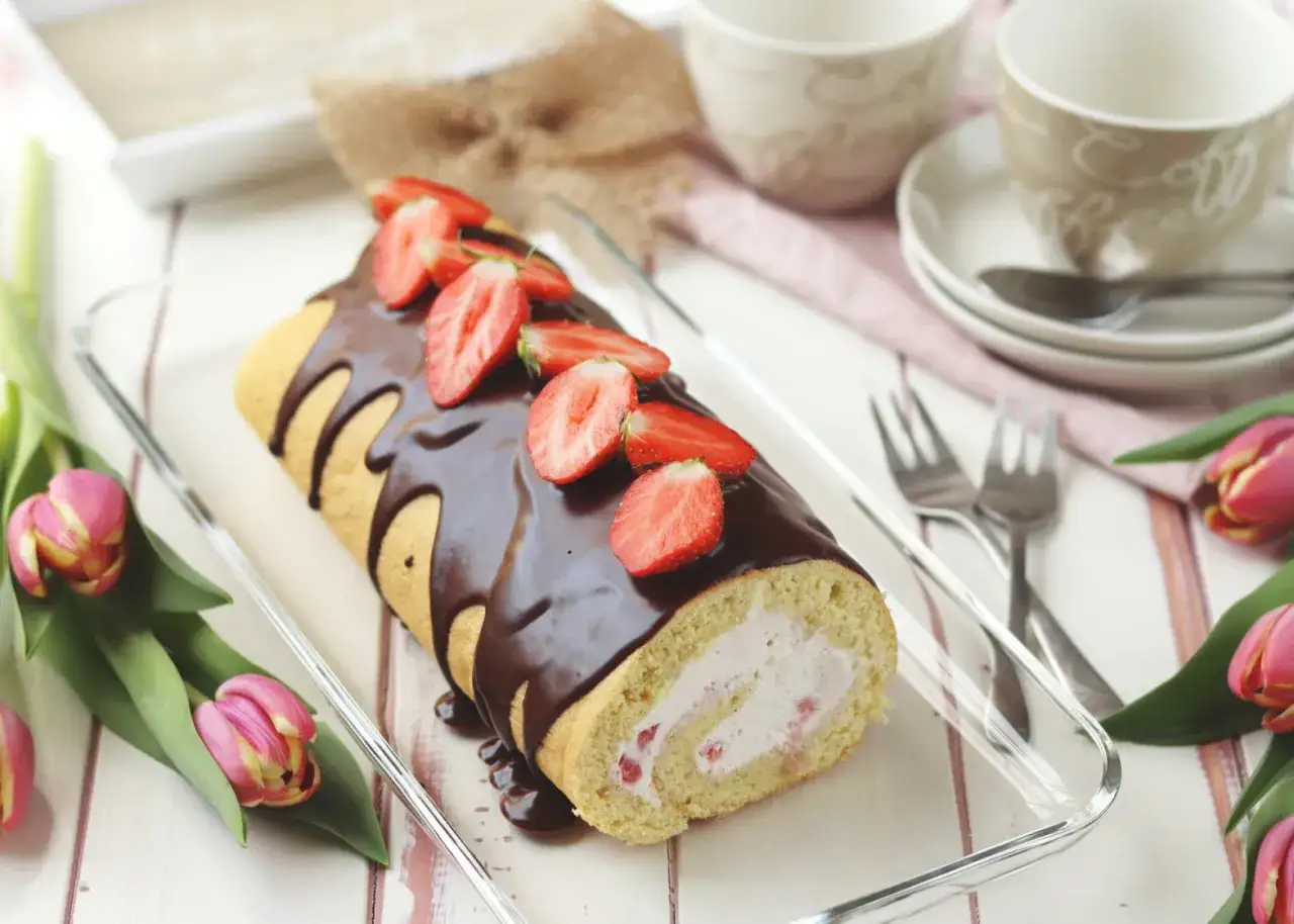 Biskuitrolle Landfrauen mit Schokoglasur und Erdbeeren, ein Genuss für jeden Kaffeetisch.