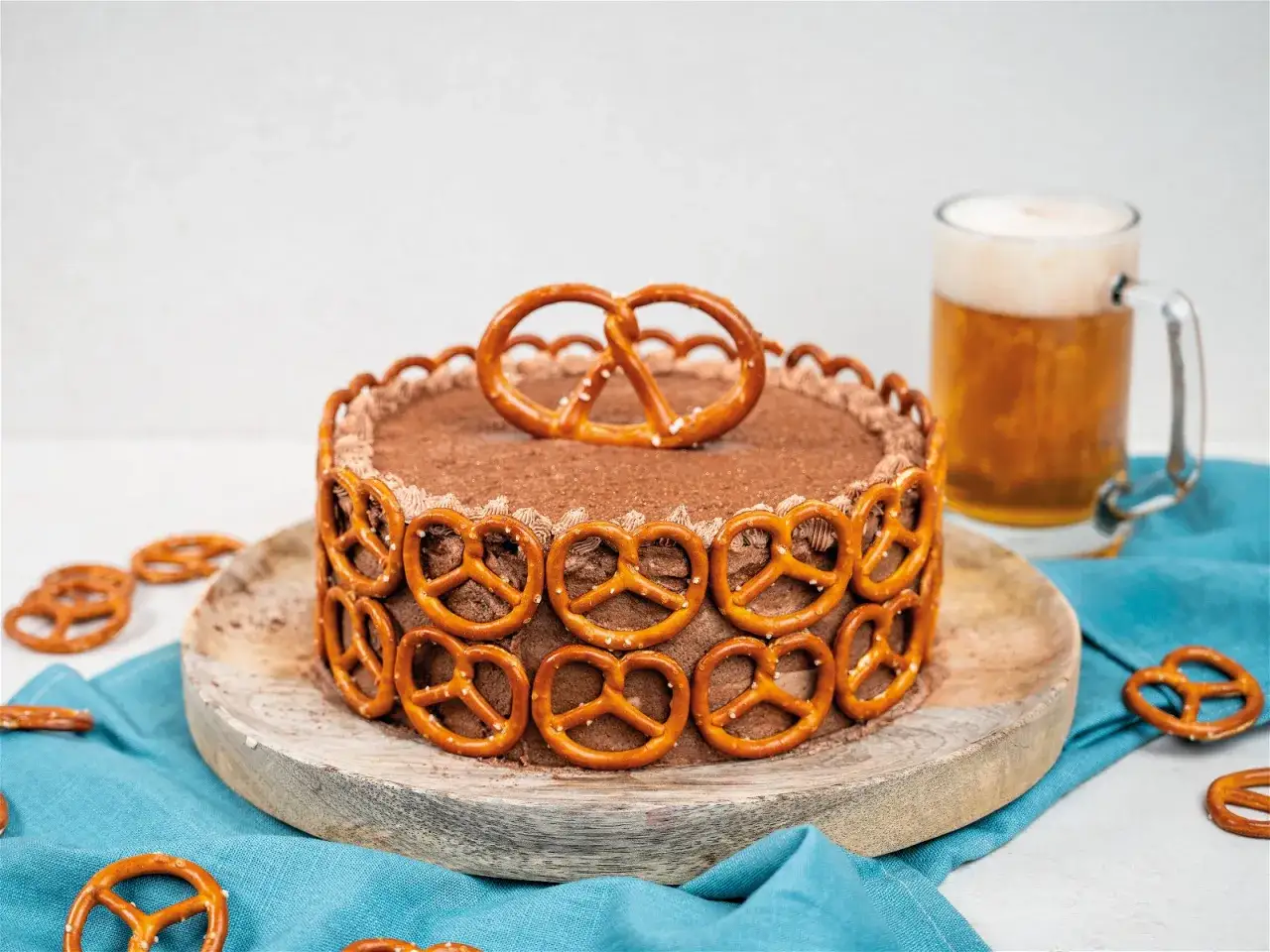 Schokoladenkuchen mit Brezeln dekoriert, perfekt für den Vatertag. Daneben ein kühles Bier.