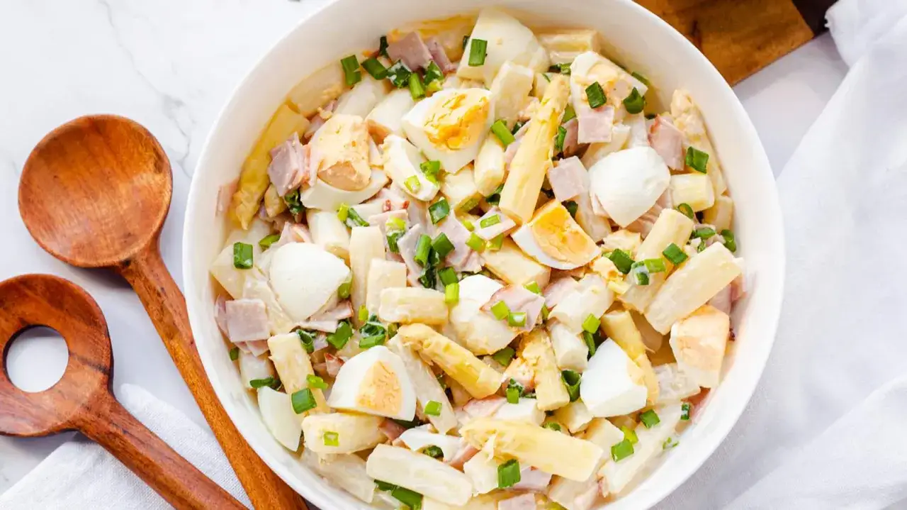 Ein cremiger Spargelsalat mit Ei und Schinken, garniert mit Schnittlauch. Dieser weltbester Spargelsalat ist ein Frühlingsgenuss!