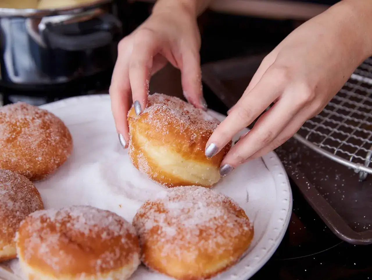 Hände zuckern frisch gebackene Berliner. Ein köstliches berliner rezept zum Nachbacken.