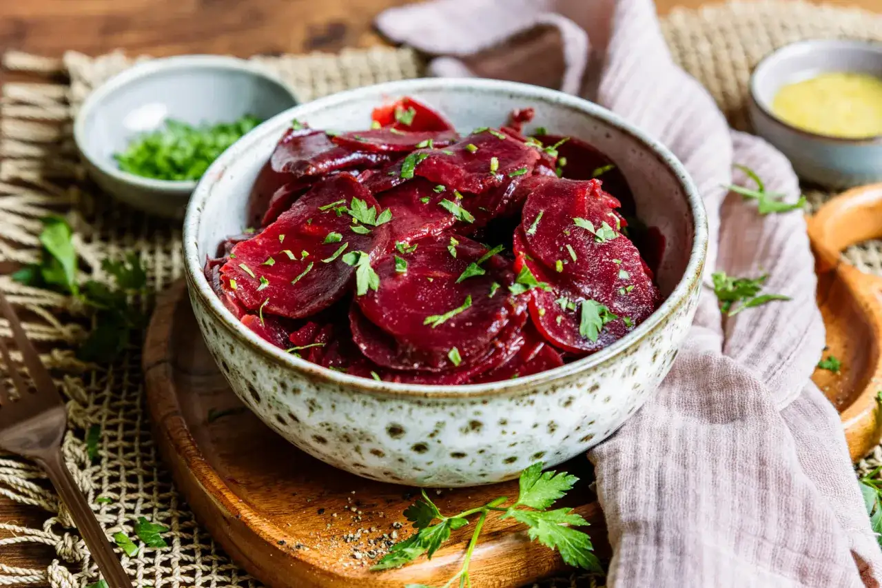 Schmackhafter rote Bete Salat nach Omas Art, mit frischer Petersilie garniert, serviert in einer rustikalen Schüssel.