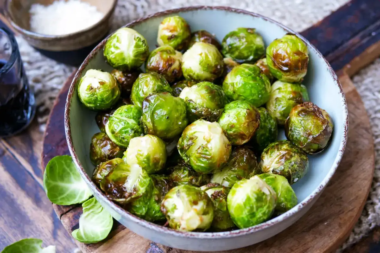 Knusprig-brauner Rosenkohl im Airfryer, glasiert und appetitlich in einer Schüssel angerichtet.