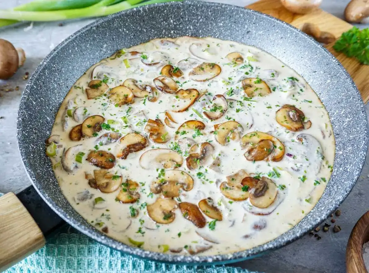 Cremige Rahmchampignons in einer Pfanne, ein köstliches Rezept für ein schnelles Abendessen.
