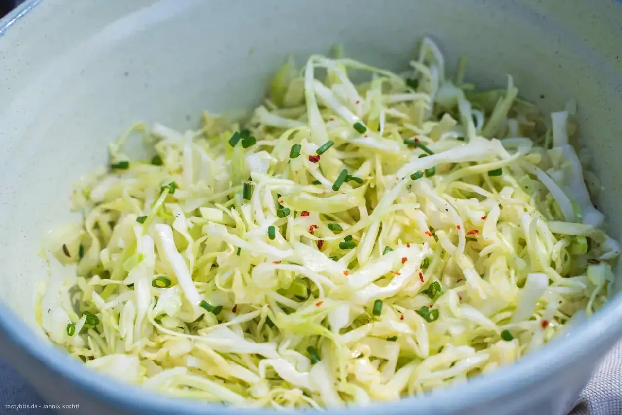 Frischer, knackiger Spitzkohlsalat, wie ihn Oma macht, garniert mit Schnittlauch und Chiliflocken.