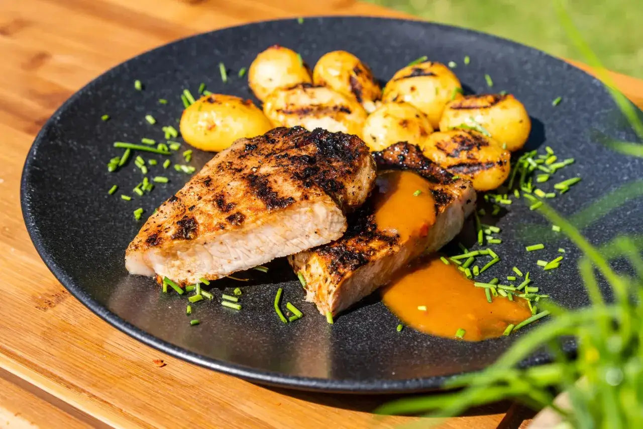 Saftige Koteletts mit gegrillten Kartoffeln und Sauce, ein tolles kotelett rezept für den Sommer.