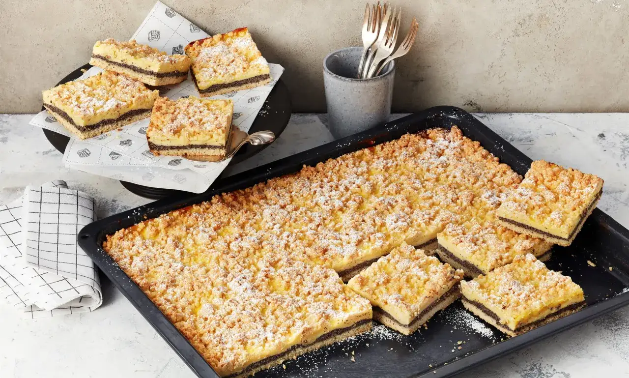 Saftiger Mohnkuchen mit Pudding und Streuseln, frisch aus dem Blech geschnitten. Ein Genuss für jeden Kaffeetisch.