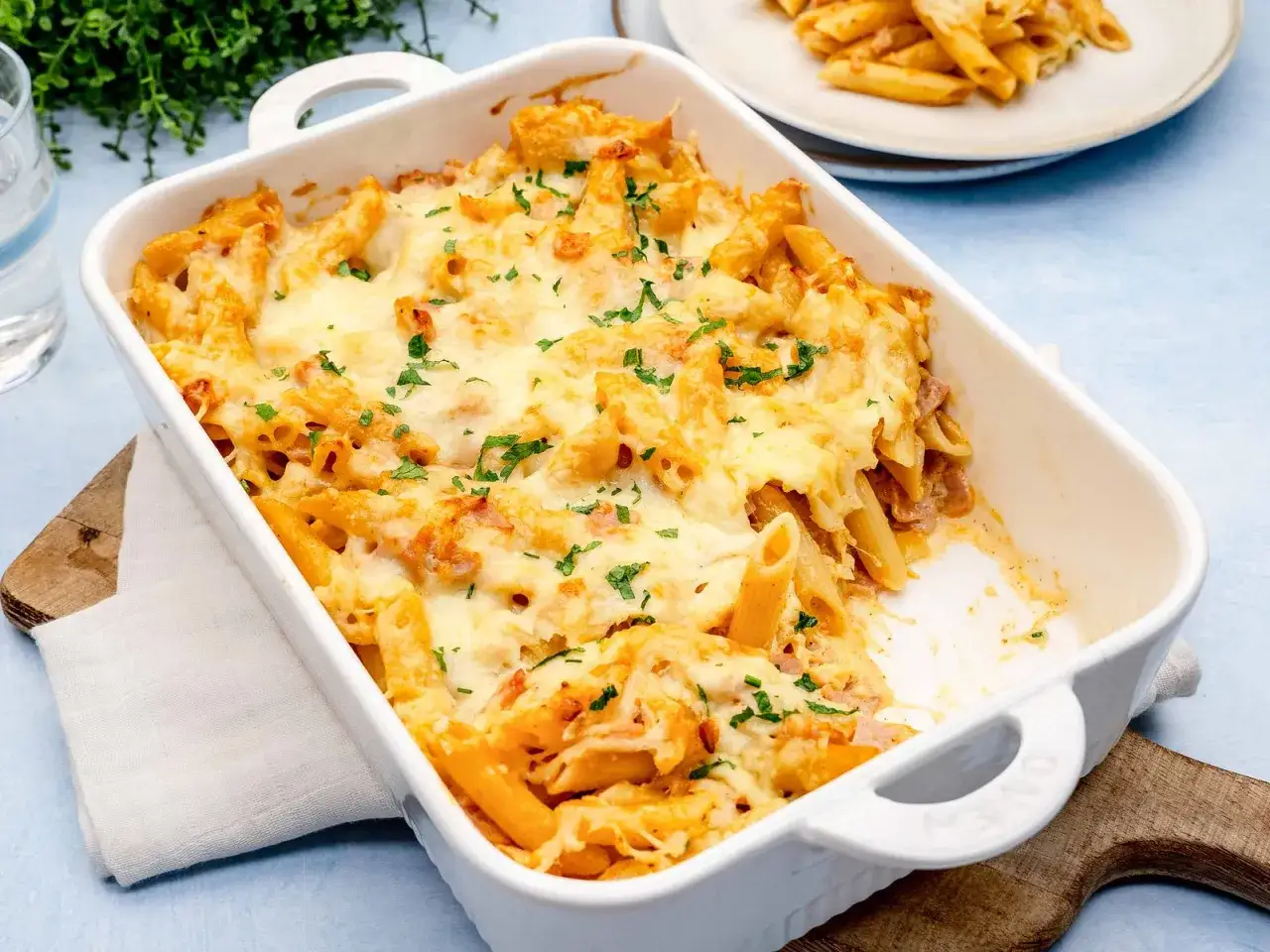 Herzhaftes Nudel Schinken Gratin mit geschmolzenem Käse und Petersilie, bereit zum Servieren.