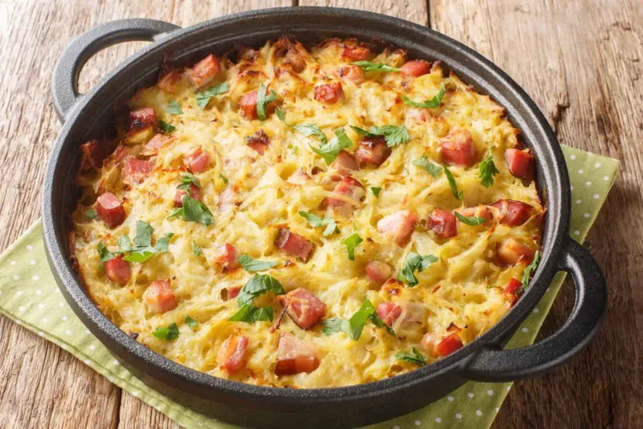 Herzhaftes Kartoffelauflauf Rezept mit Speckwürfeln und frischer Petersilie, goldbraun gebacken in einer gusseisernen Pfanne.