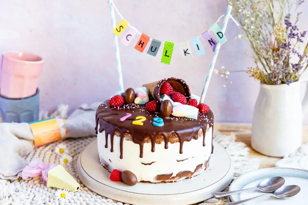 Ein bunter Geburtstagskuchen für Kinder mit Schokoladenglasur, Beeren und einer