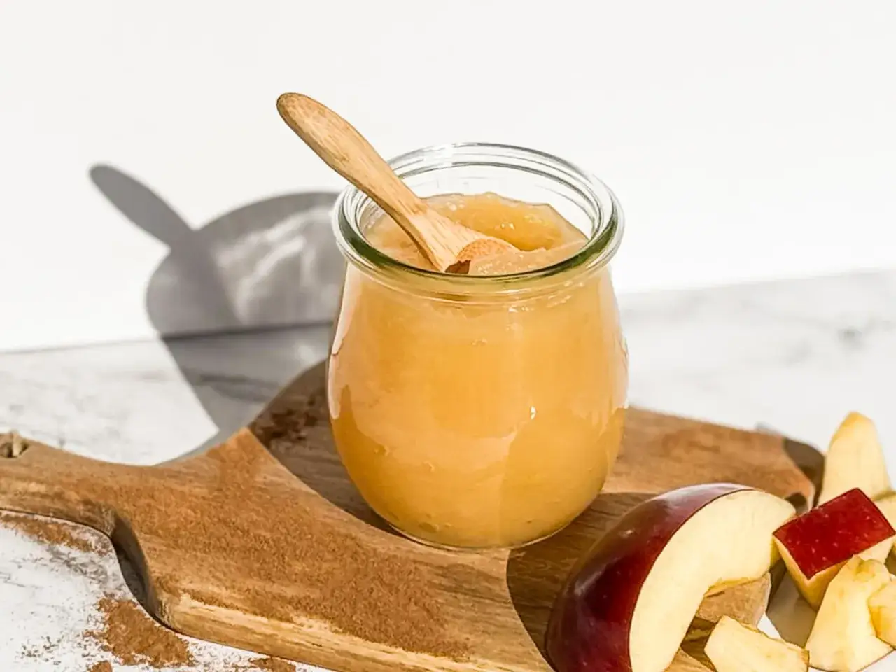 Glas mit selbstgemachtem Apfelmus, Holzschale mit Zimt und Apfelstücken. Perfekt zum Apfelmus selber machen!