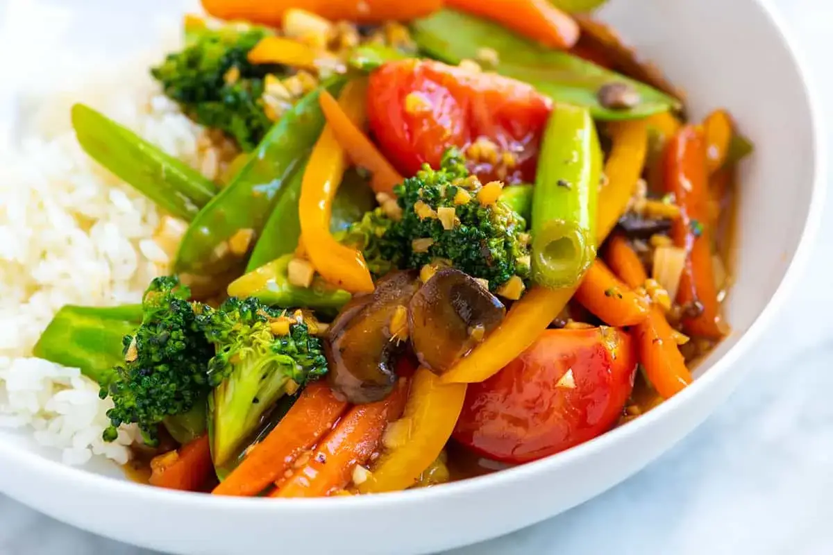 Bunte Brokkoli-Pfanne mit Reis: knackiger Brokkoli, Paprika, Karotten und Zuckerschoten in einer würzigen Sauce.