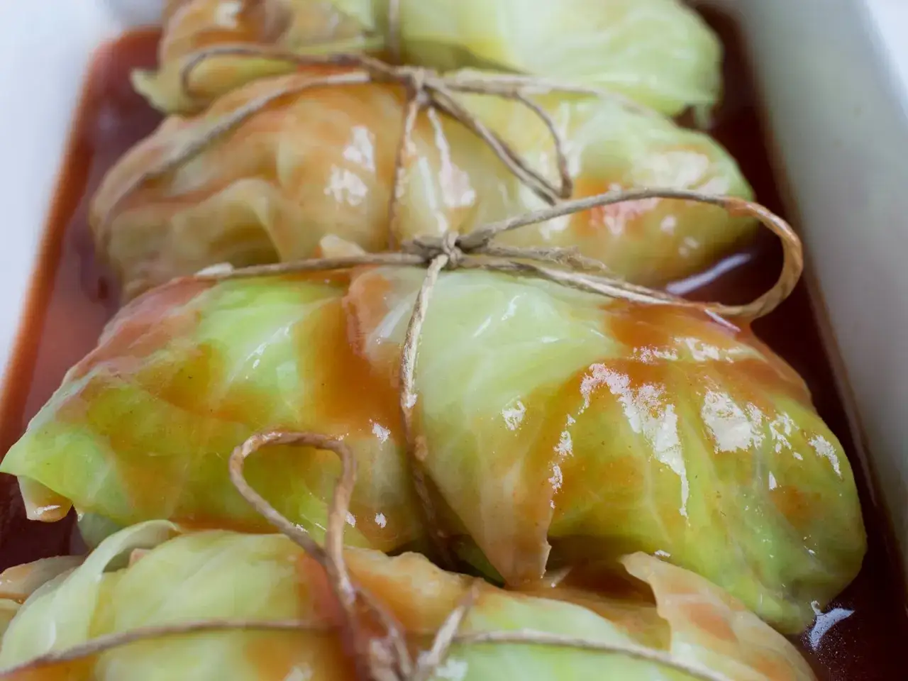 Krautwickel im Br&auml;ter, mit Schnur gebunden und in Tomatensauce geschmort. Ein k&ouml;stliches Krautwickel Rezept.