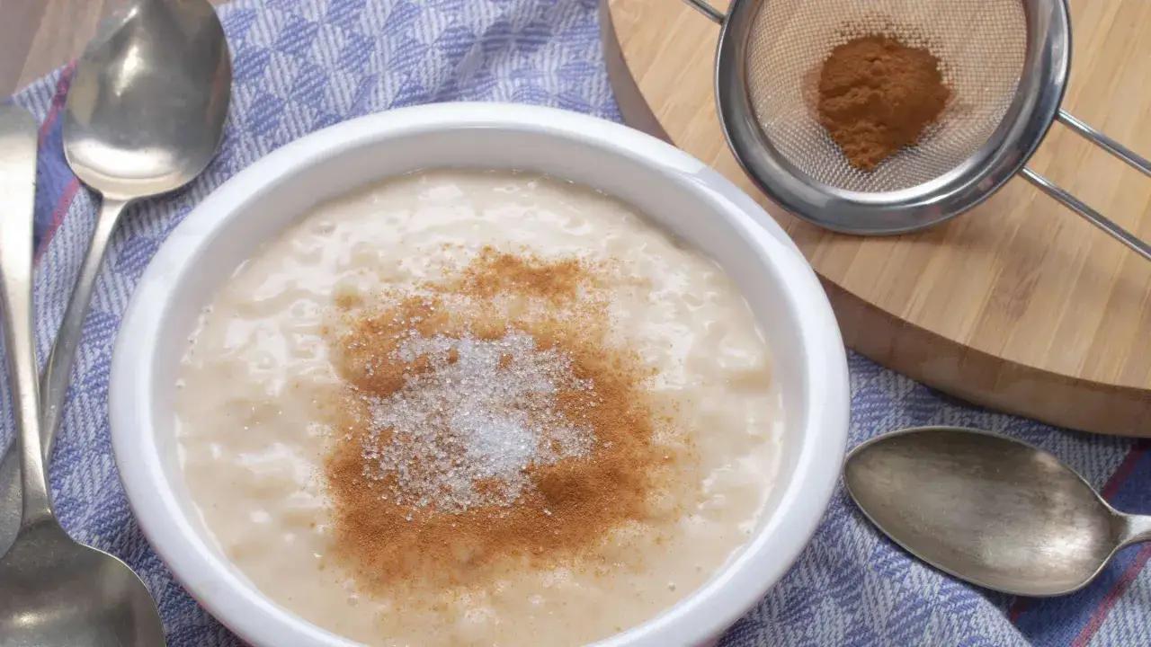 Cremiger Milchreis, bestreut mit Zimt und Zucker, wartet auf seine Löffel. Ein einfaches, leckeres Milchreis Rezept.