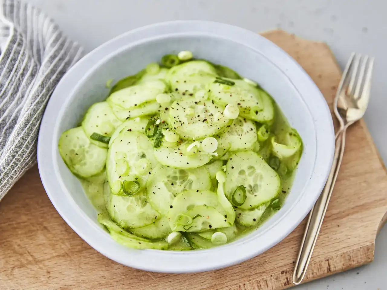 Erfrischender Gurkensalat, perfekt für jedes Sommer-Gurkensalat Rezept. Mit frischen Gurkenscheiben und Frühlingszwiebeln, gewürzt mit Pfeffer.
