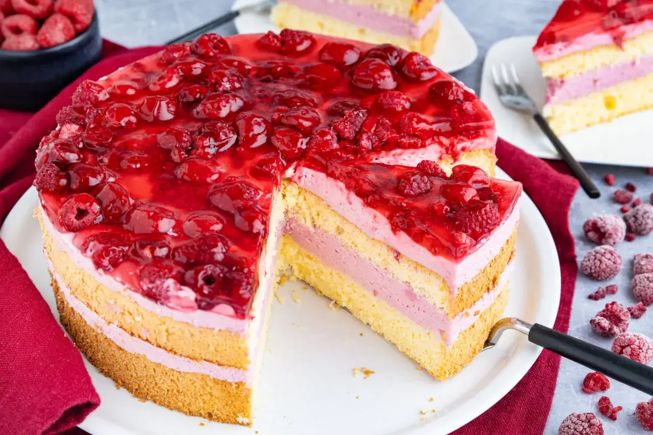 Himbeertorte mit gefrorenen Himbeeren: saftiger Biskuit, cremige Füllung und fruchtiger Belag. Ein köstliches Rezept!
