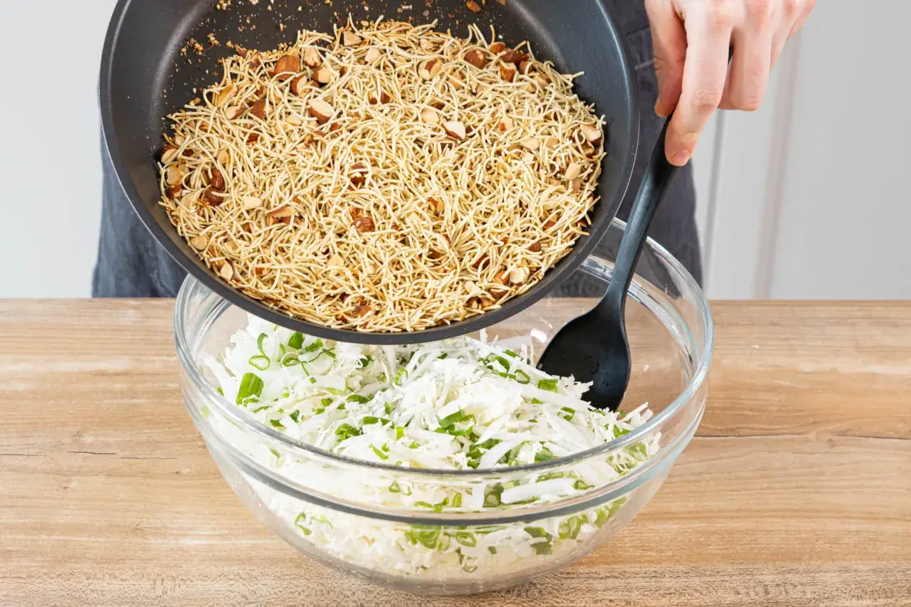 Knusprige Nudeln mit Mandeln werden über einen Kohl-Frühlingszwiebel-Salat gegossen. Ein perfekter