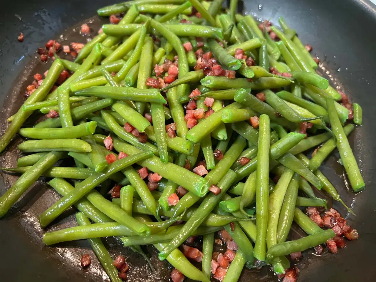 Frische grüne Brechbohnen mit Speckwürfeln in einer Pfanne. Ein einfaches und leckeres Brechbohnen Rezept.