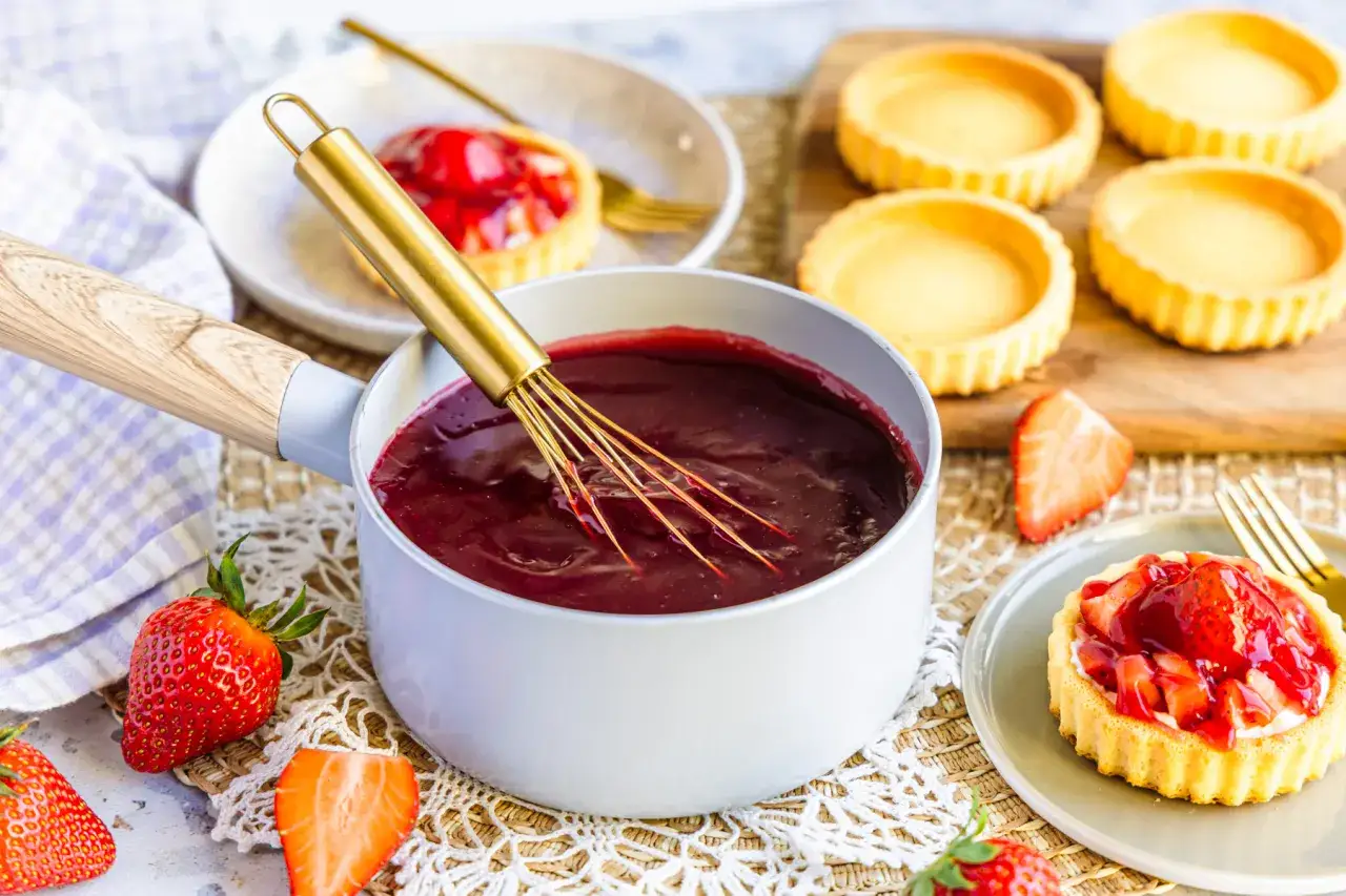 Frisch zubereiteter Tortenguss mit Erdbeeren und leeren Tartelettes. So einfach lässt sich Tortenguss selber machen!