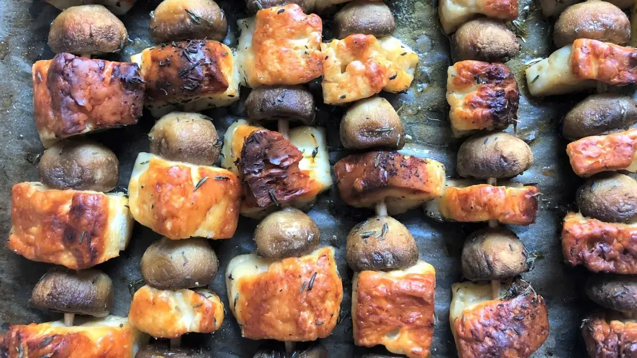 Gegrillte Champignons und K&auml;se-Spie&szlig;e, goldbraun und mit Kr&auml;utern bestreut, bereit zum Genie&szlig;en.