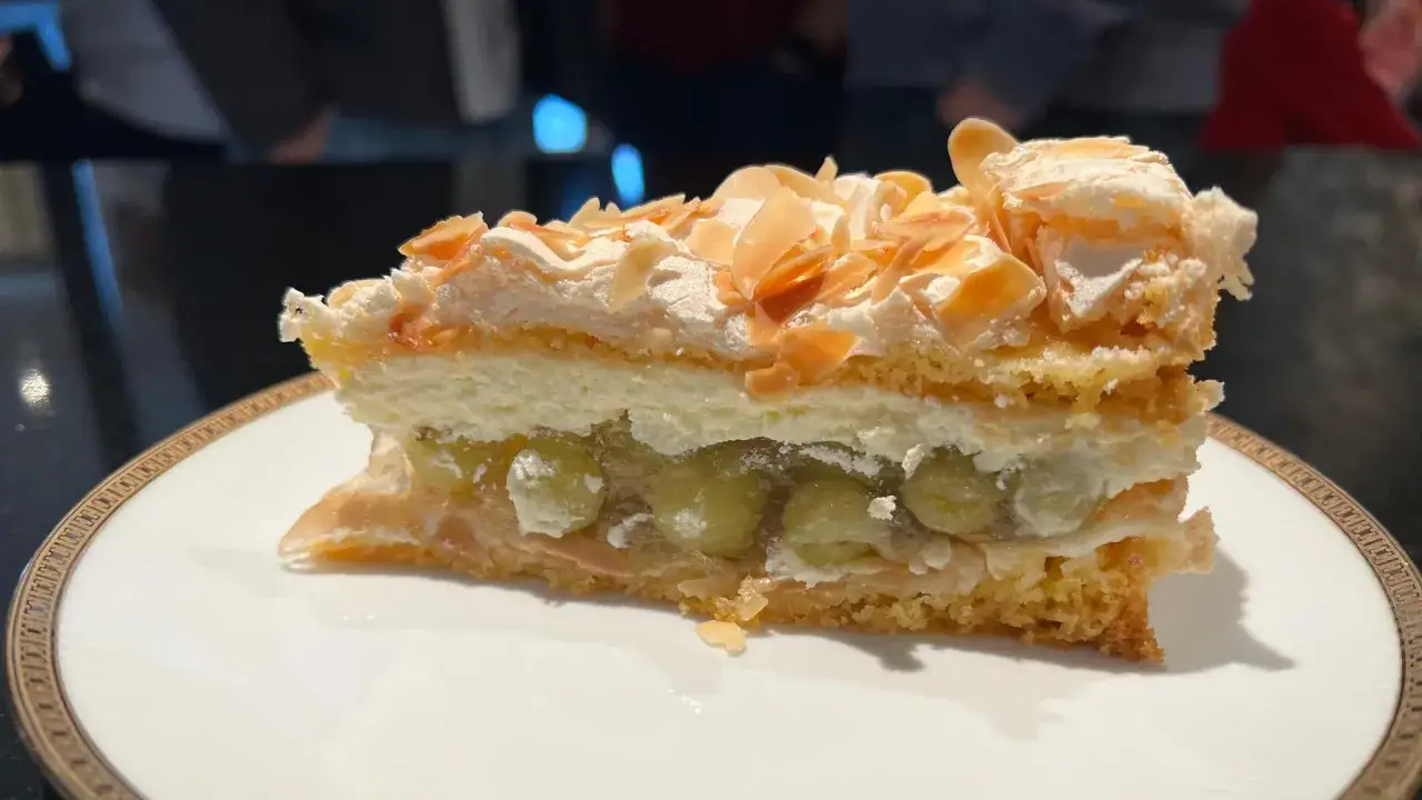Ein saftiges Stück Stachelbeer Baiser Kuchen mit Mandelsplittern und einer luftigen Creme.