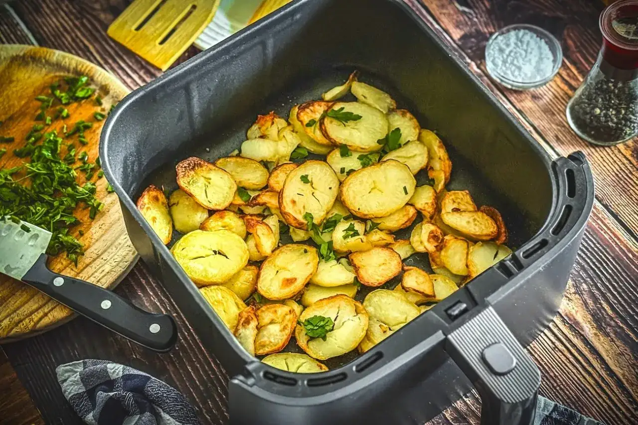 Goldbraune bratkartoffeln im Airfryer, garniert mit frischer Petersilie. Perfekt für eine schnelle und knusprige Beilage.