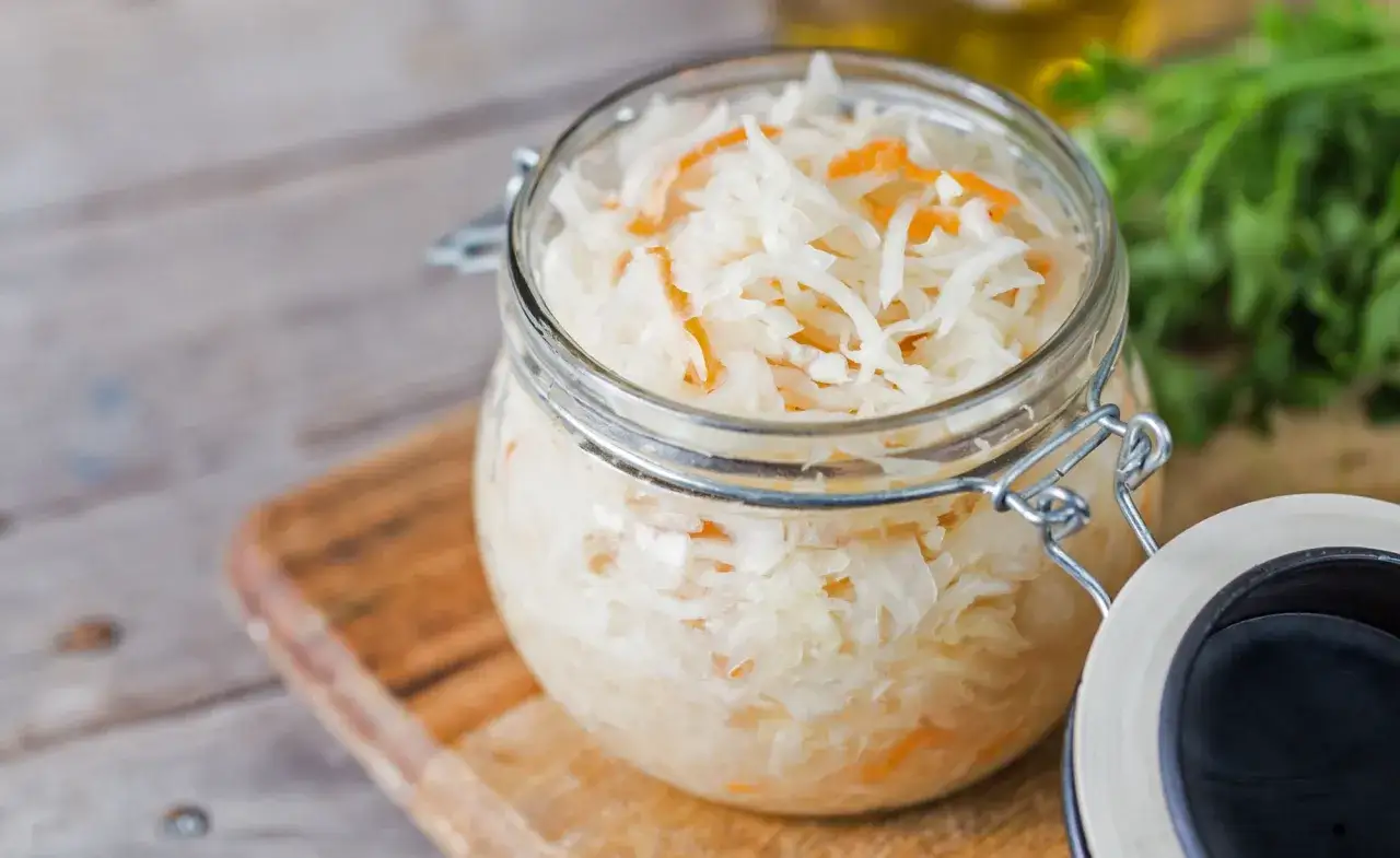 Frisches Sauerkraut im Glas, bereit zum Fermentieren. So einfach ist Sauerkraut selber machen!