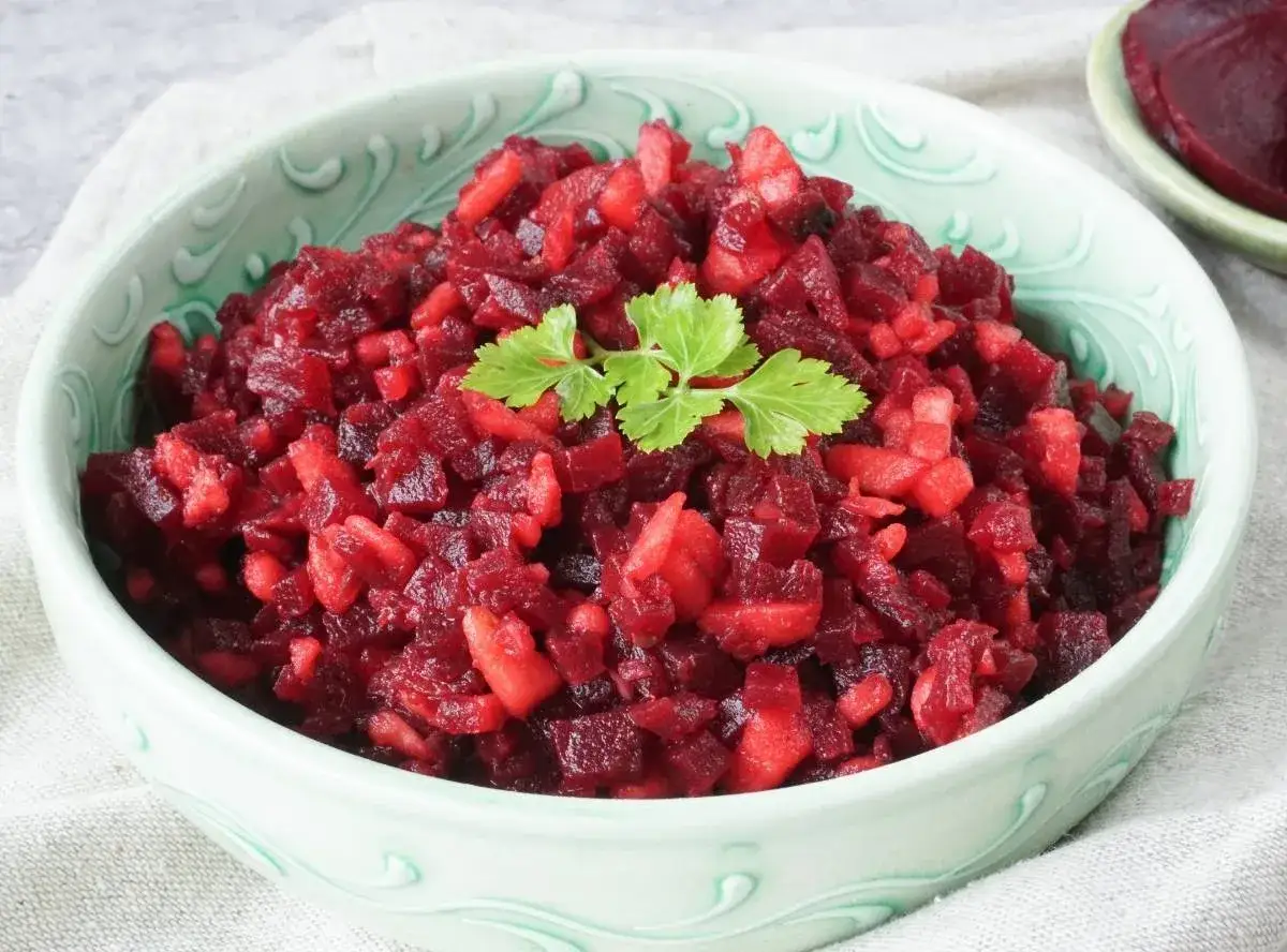 Schmackhaftes Rezept für Rote Bete Salat mit Apfelstücken, garniert mit Petersilie. Ein bunter und gesunder Genuss.