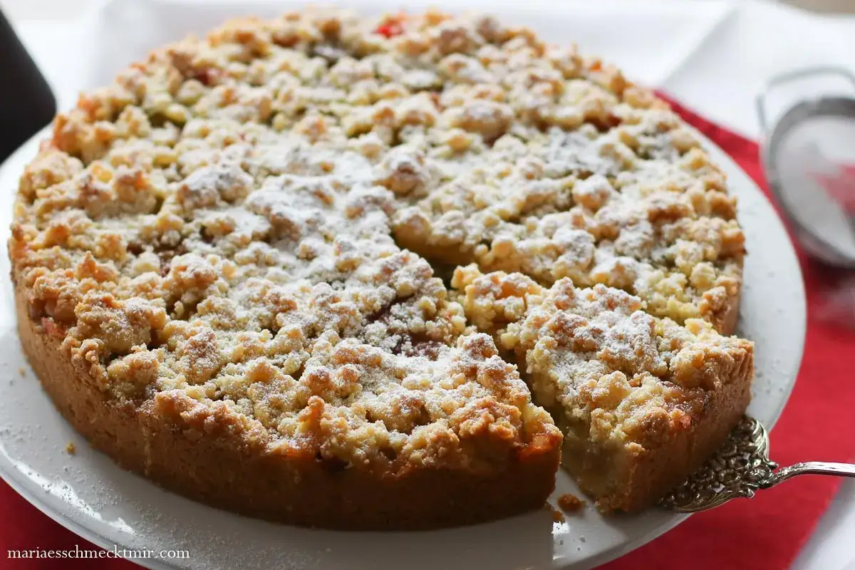 Saftiger Rhabarberkuchen mit Streuseln, perfekt nach diesem Rhabarberkuchen Rezept. Mit Puderzucker bestäubt.