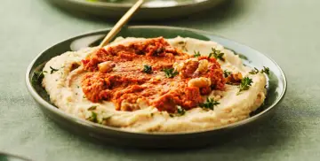 Cremiges Bohnenmus mit würziger Tomaten-Walnuss-Mischung und frischen Kräutern. Ein köstliches Rezept für Bohnenmus!